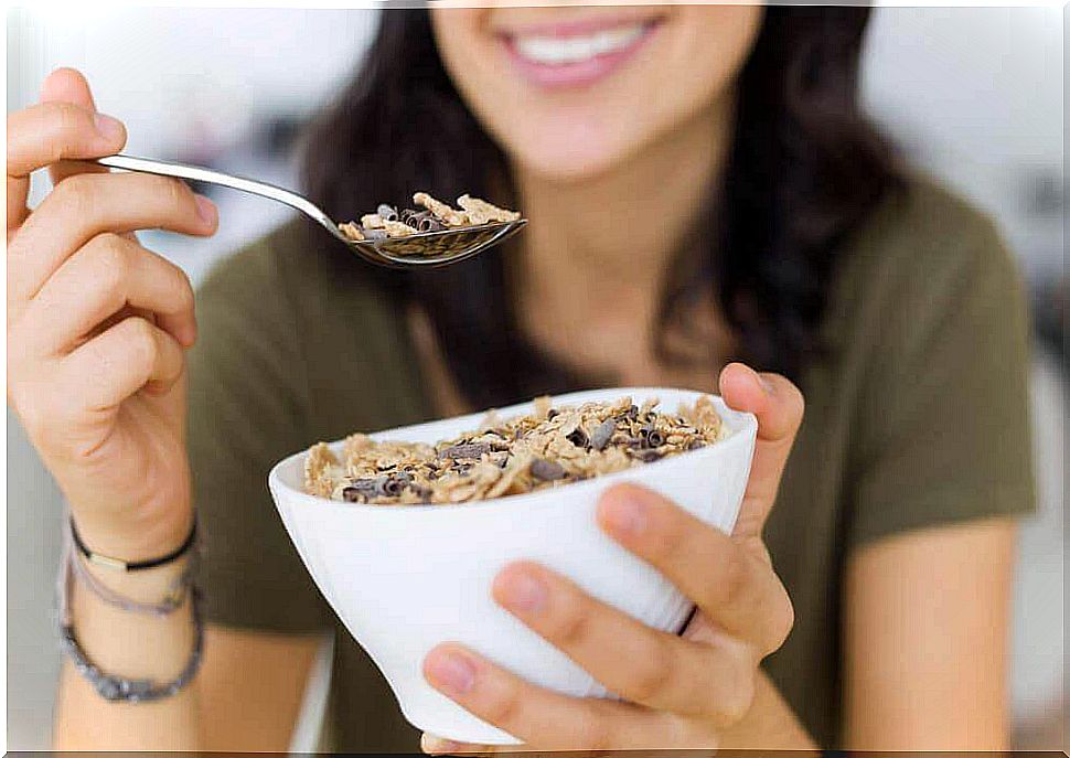 A woman eats a bowl of cereal.