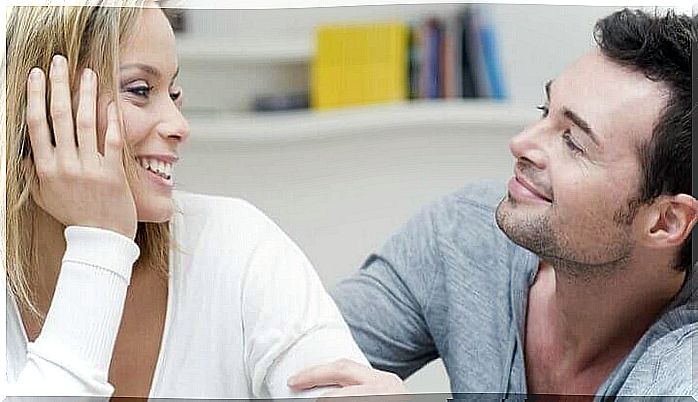 A woman and a man talk to each other and laugh.