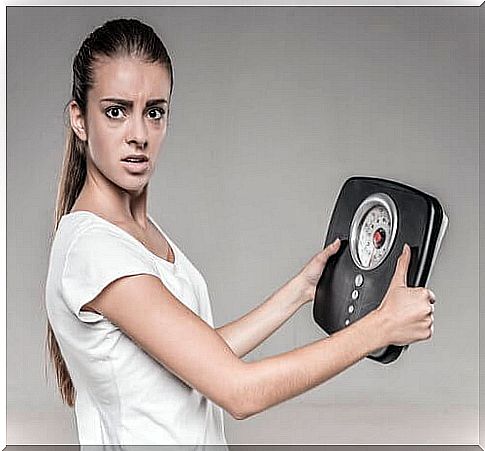 high blood sugar: woman loses weight in a short time and checks her weight with the scales